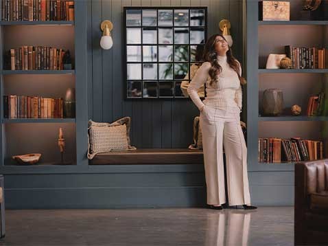 Woman wearing all white in a warm library setting